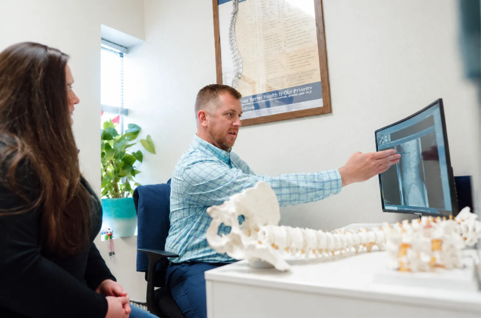 Chiropractor explaining spine care to a patient